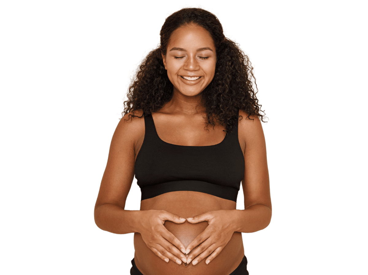 Pregnant woman in black tank top with hands making heart shape over exposed belly