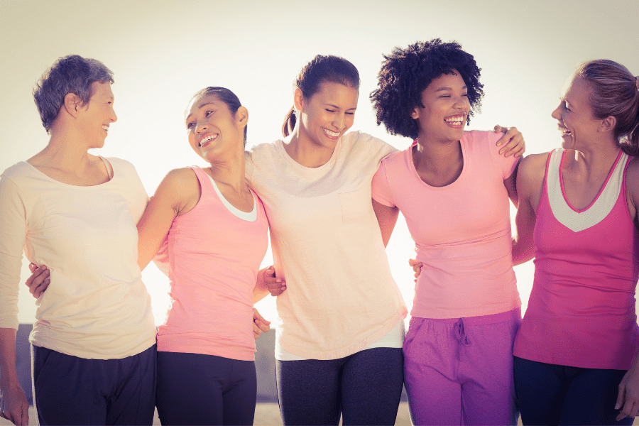 A group of women stand arm in arm