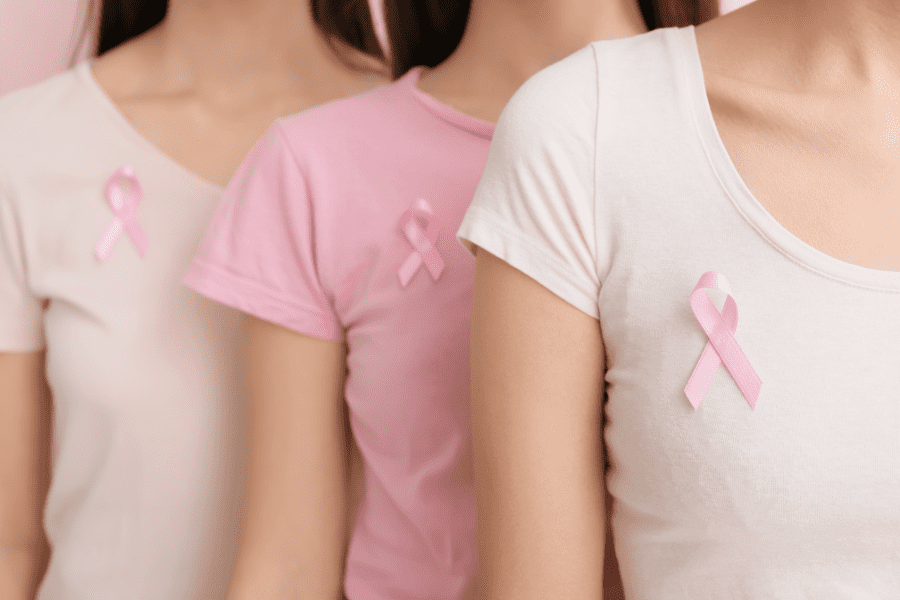 women wear pink ribbons in support of breast cancer research