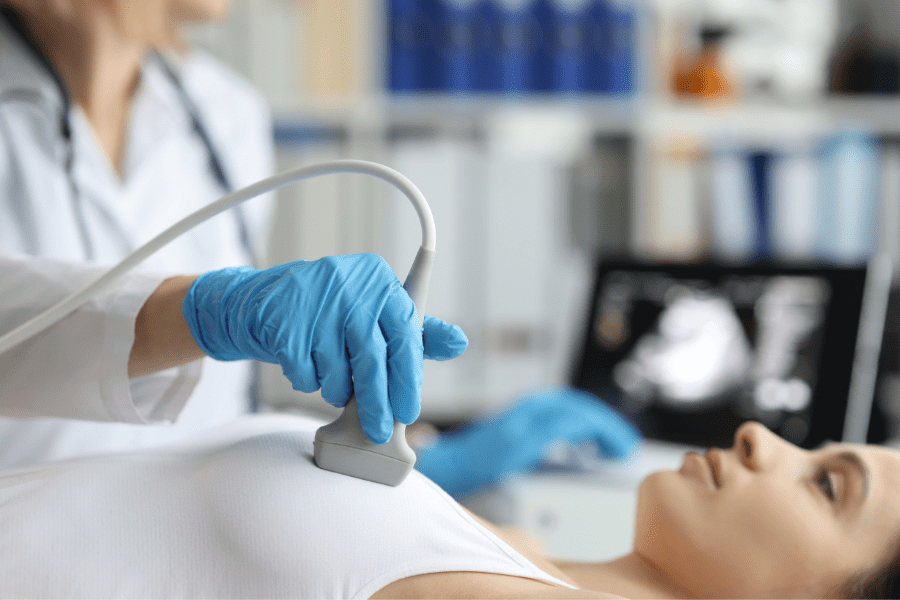 Provider examines a patient for breast cancer with a sonogram wand