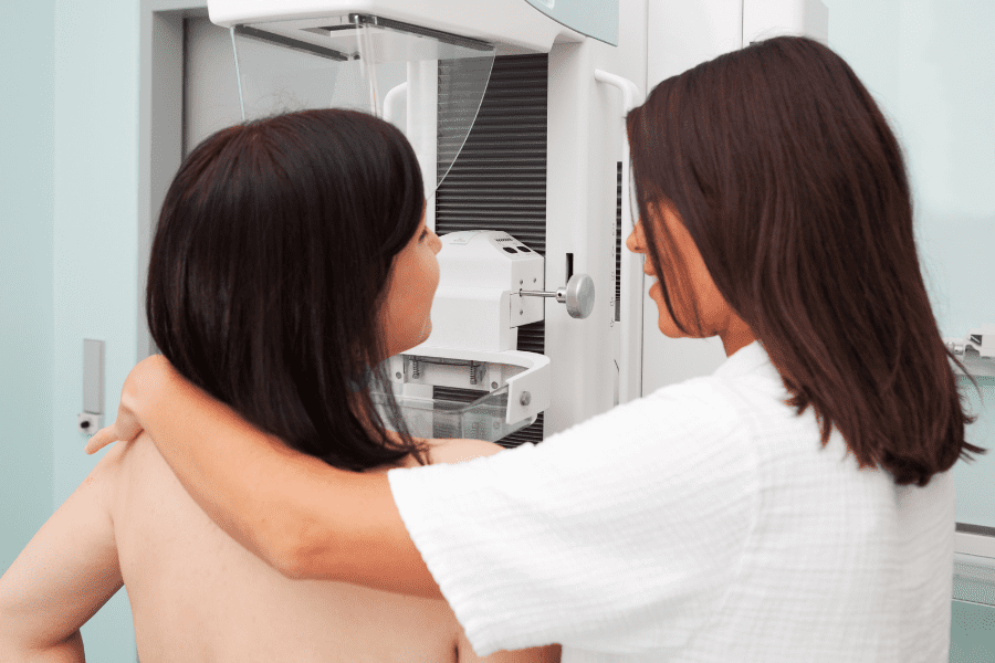 A provider assists a woman during a mammogram