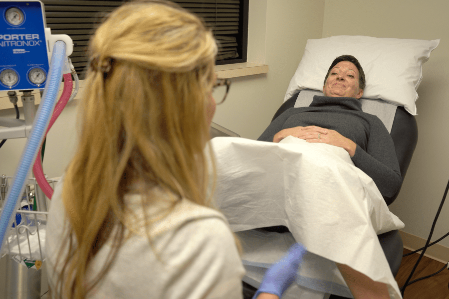 women laying down in medical office being prepped for a bladder examination by female doctor